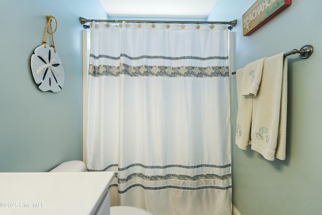 full bathroom featuring toilet and a shower with curtain