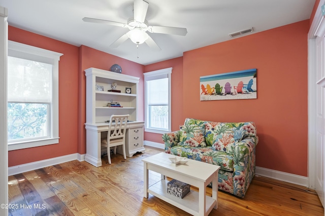 home office featuring wood finished floors, visible vents, a ceiling fan, and baseboards