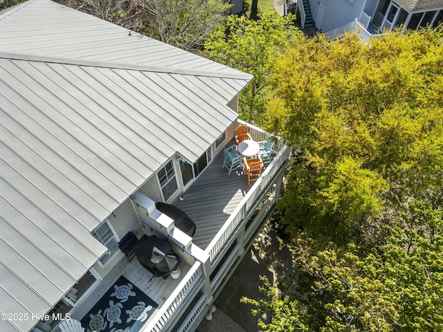 view of side of property featuring a standing seam roof, metal roof, and outdoor dining area