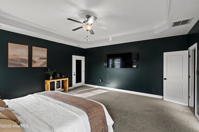 bedroom featuring visible vents, baseboards, ornamental molding, a tray ceiling, and carpet flooring