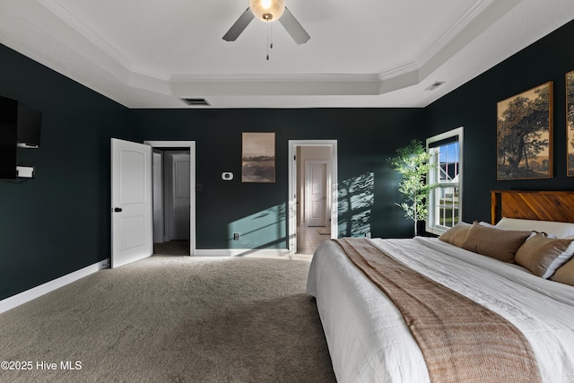 carpeted bedroom featuring crown molding, visible vents, baseboards, and a raised ceiling