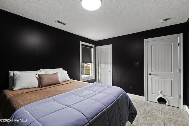 bedroom with visible vents, baseboards, carpet flooring, and a textured ceiling
