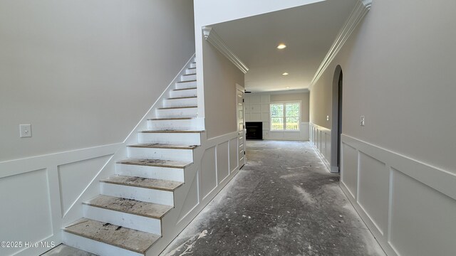 295 E Ivybridge Dr, Hubert, NC 28539 - staircase featuring ornamental molding, a wainscoted wall, a decorative wall, and a fireplace