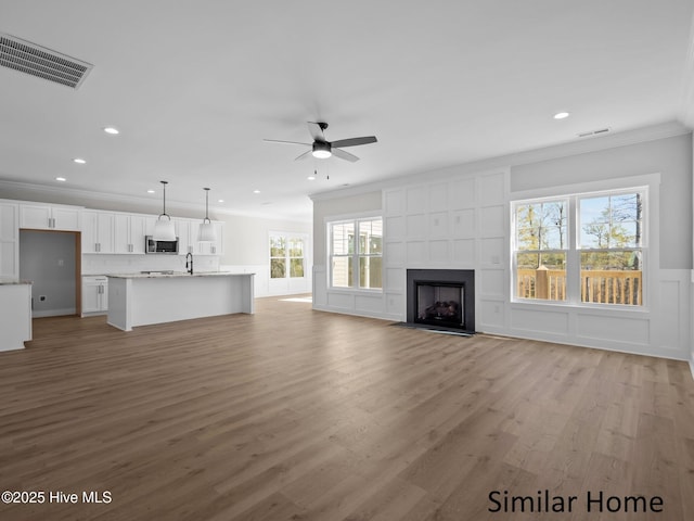 295 E Ivybridge Dr, Hubert, NC 28539 - unfurnished living room with a decorative wall, ceiling fan, crown molding, recessed lighting, and light wood finished floors