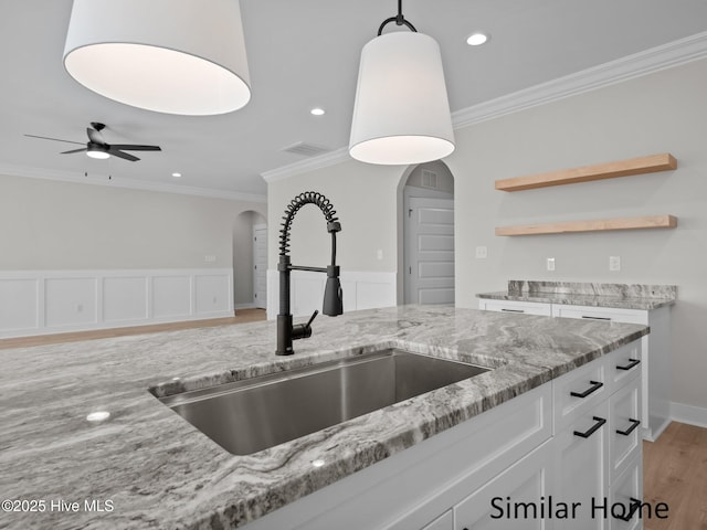 295 E Ivybridge Dr, Hubert, NC 28539 - kitchen featuring arched walkways, ornamental molding, light stone countertops, white cabinets, and ceiling fan