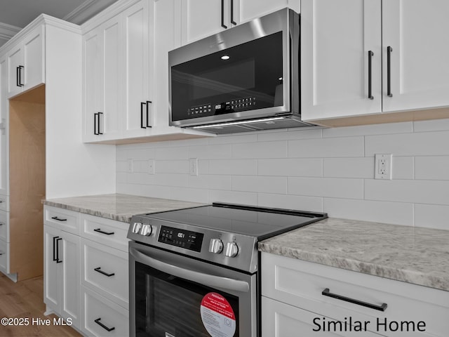 295 E Ivybridge Dr, Hubert, NC 28539 - kitchen with stainless steel appliances, white cabinets, light stone countertops, backsplash, and light wood-type flooring