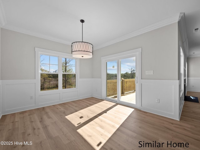 295 E Ivybridge Dr, Hubert, NC 28539 - unfurnished dining area with wainscoting, crown molding, wood finished floors, plenty of natural light, and a decorative wall