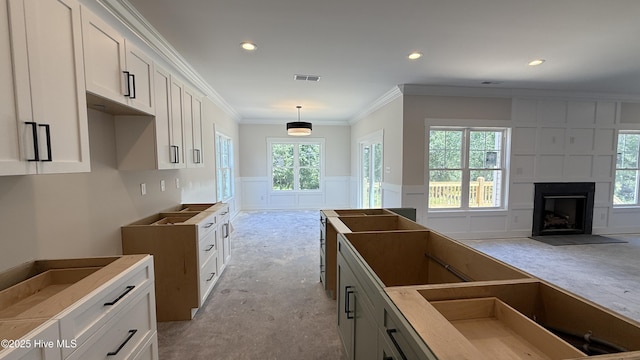 295 E Ivybridge Dr, Hubert, NC 28539 - kitchen featuring white cabinetry, a large fireplace, a decorative wall, crown molding, and pendant lighting