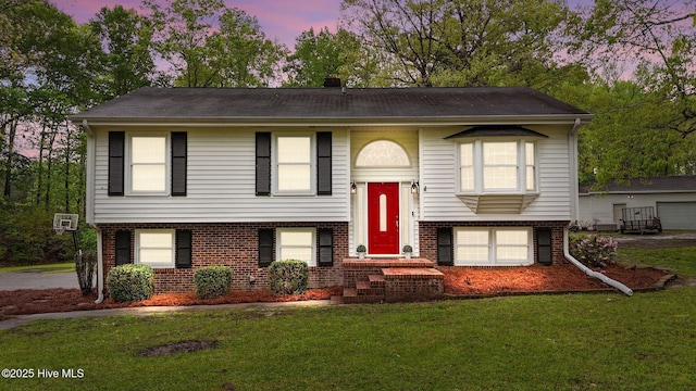 379 Greenbrier Rd, Tarboro, NC 27886 - bi-level home with brick siding, a garage, and a lawn