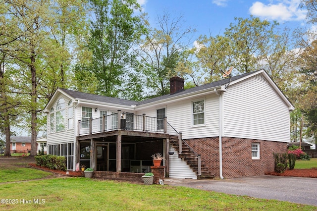 379 Greenbrier Rd, Tarboro, NC 27886 - rear view of property featuring a chimney, driveway, stairs, a sunroom, and a lawn