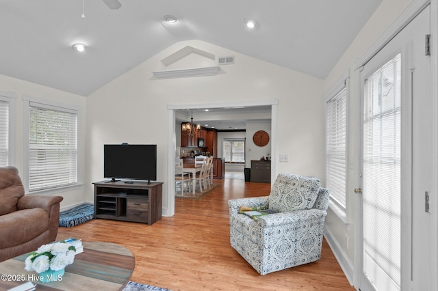 379 Greenbrier Rd, Tarboro, NC 27886 - living room with visible vents, baseboards, light wood-style floors, vaulted ceiling, and ceiling fan with notable chandelier