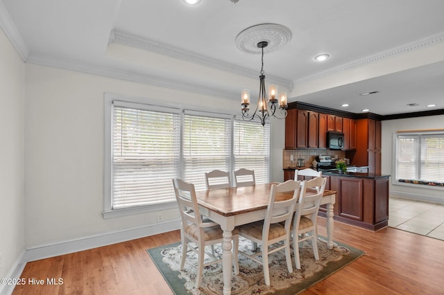 379 Greenbrier Rd, Tarboro, NC 27886 - dining room with light wood-type flooring, baseboards, an inviting chandelier, and crown molding