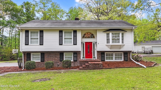 379 Greenbrier Rd, Tarboro, NC 27886 - split foyer home with brick siding, an AC wall unit, a chimney, and a front lawn
