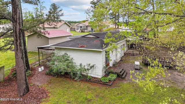 379 Greenbrier Rd, Tarboro, NC 27886 - view of property exterior featuring a shingled roof, fence, and a lawn