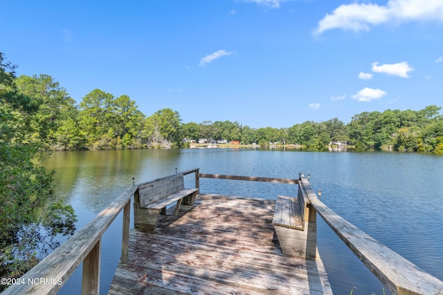 view of dock with a view of trees and a water view