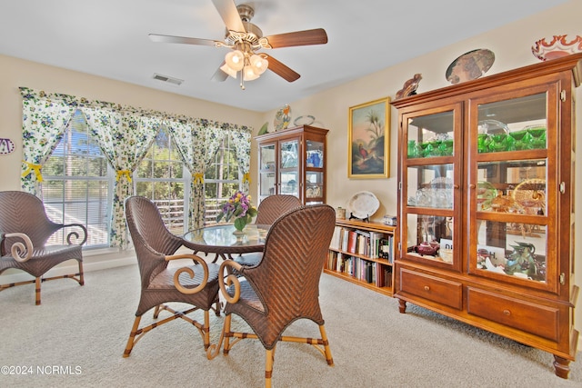 dining room with a ceiling fan, light colored carpet, and a healthy amount of sunlight