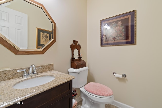half bath featuring vanity and toilet