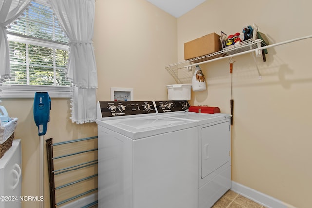 washroom with baseboards, washing machine and dryer, and laundry area