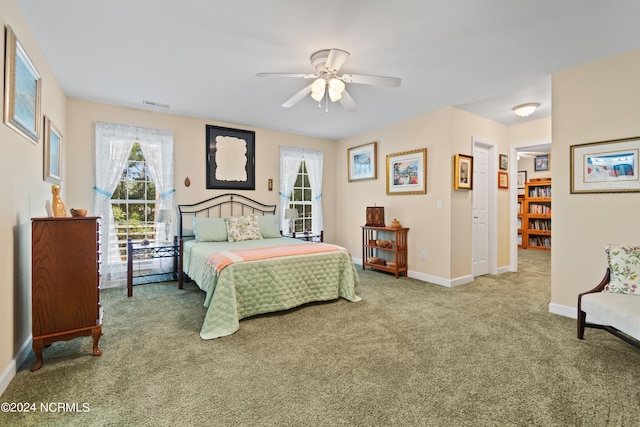 carpeted bedroom featuring visible vents, multiple windows, baseboards, and ceiling fan