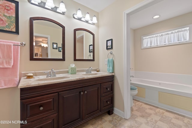 bathroom with toilet, a garden tub, double vanity, and a sink