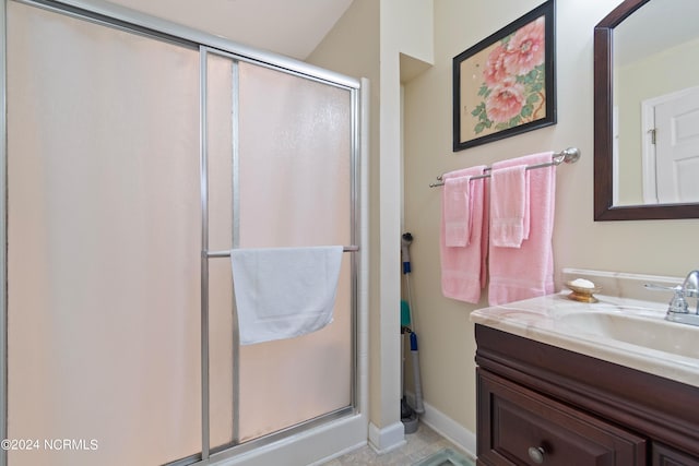bathroom with baseboards, a shower stall, and vanity