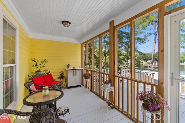 sunroom featuring a water view and a wealth of natural light
