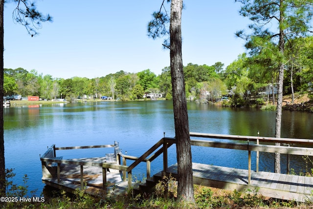 view of dock featuring a water view and a forest view