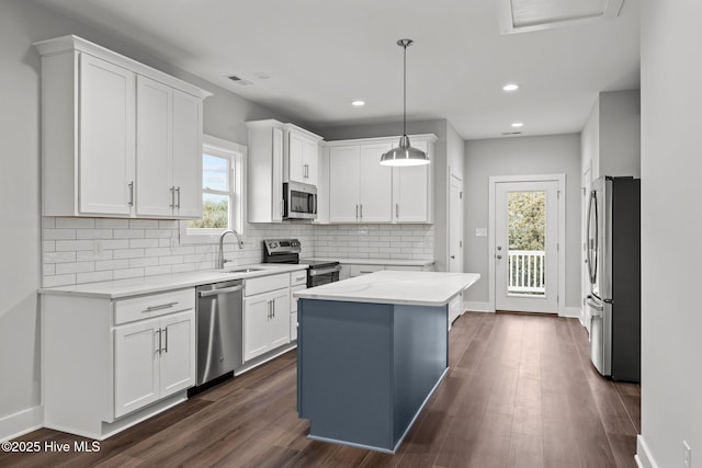 kitchen with stainless steel appliances, white cabinetry, and a sink