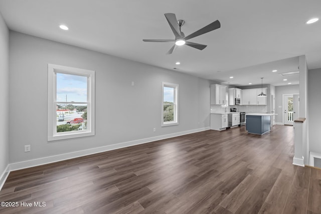 unfurnished living room featuring recessed lighting, dark wood-type flooring, baseboards, and ceiling fan