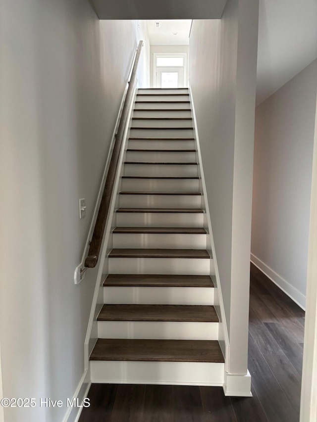stairs featuring wood finished floors and baseboards