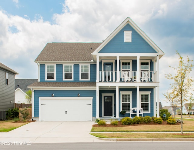 view of front of house with covered porch, a balcony, driveway, a garage, and roof with shingles