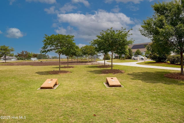 view of home's community featuring a lawn and curved driveway