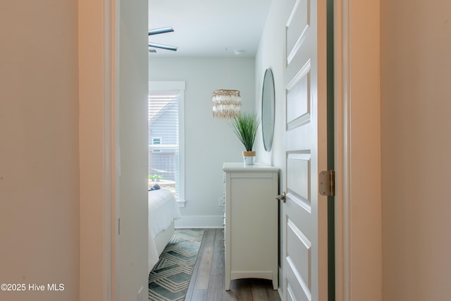 corridor with dark wood-type flooring and baseboards