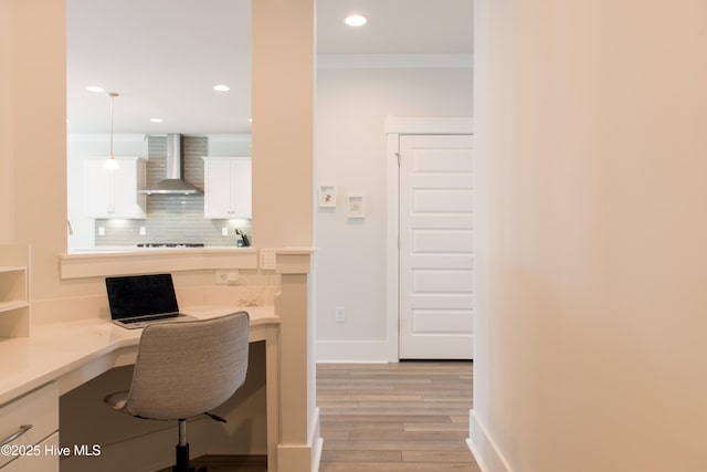 home office with built in desk, light wood-style floors, recessed lighting, baseboards, and ornamental molding