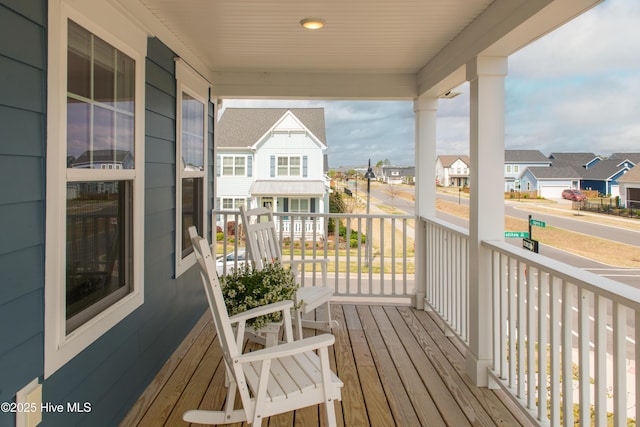 wooden deck featuring a residential view and covered porch