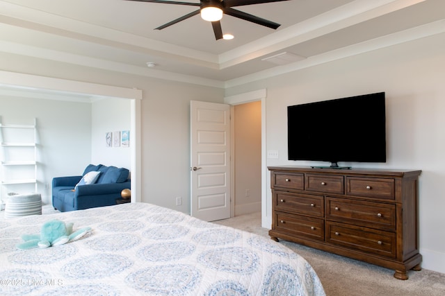 bedroom with light carpet, a raised ceiling, and ceiling fan