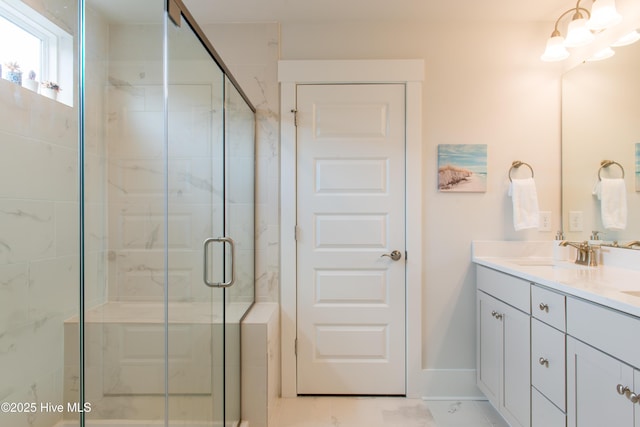 full bath featuring a shower stall, vanity, and baseboards
