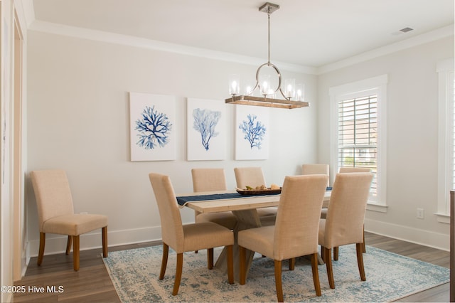 dining room featuring a chandelier, wood finished floors, baseboards, and ornamental molding