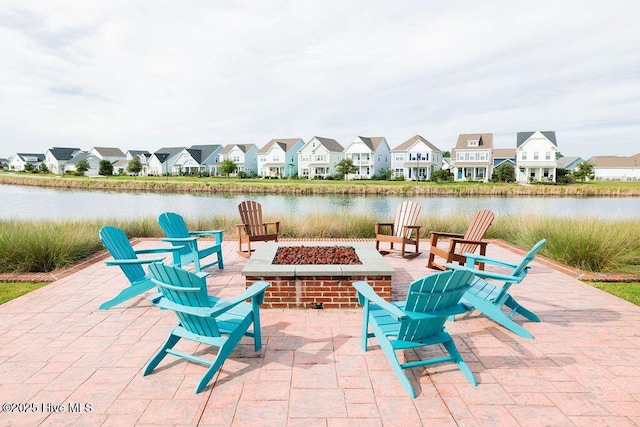 view of patio with a fire pit, a residential view, and a water view