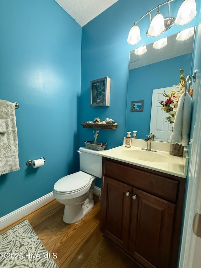 165 Laurel Oak Ln, Pinebluff, NC 28373 - half bathroom featuring wood finished floors, toilet, baseboards, and vanity
