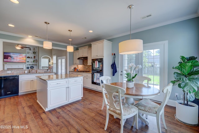 kitchen with plenty of natural light, black appliances, and backsplash