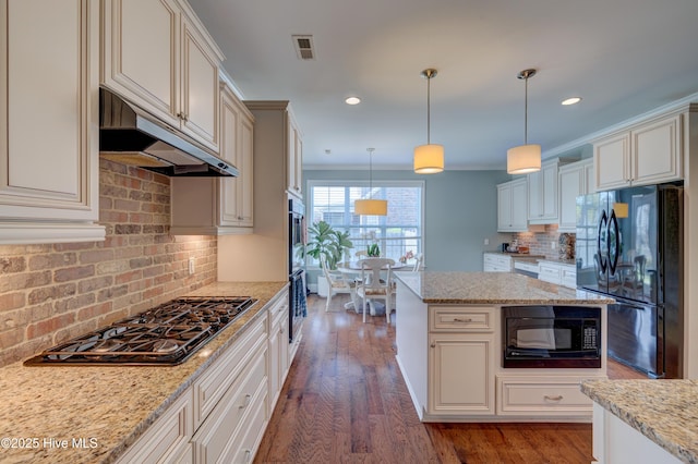 kitchen with decorative backsplash, visible vents, black appliances, and wood finished floors