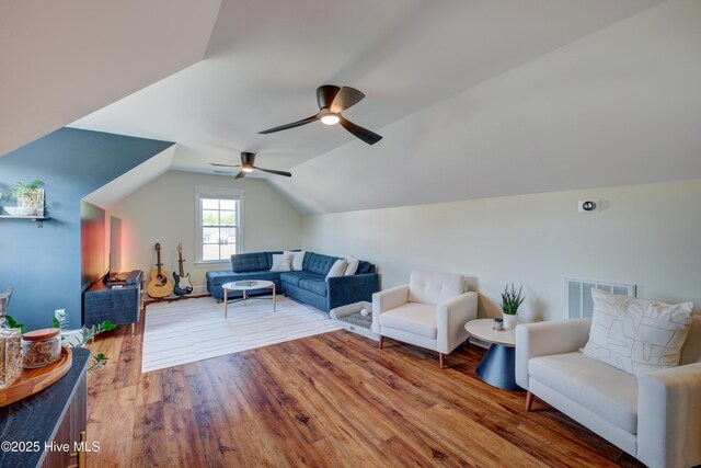 living area featuring a ceiling fan, wood finished floors, vaulted ceiling, and visible vents