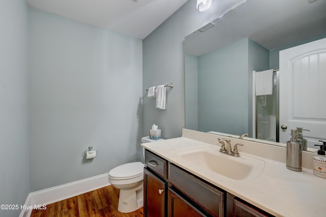 bathroom with vanity, baseboards, toilet, visible vents, and wood finished floors