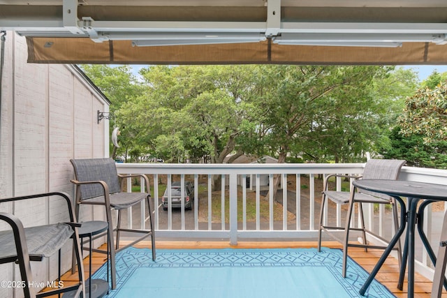 balcony featuring view of wooded area