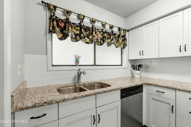 kitchen with dishwasher, a sink, decorative backsplash, white cabinets, and a textured ceiling
