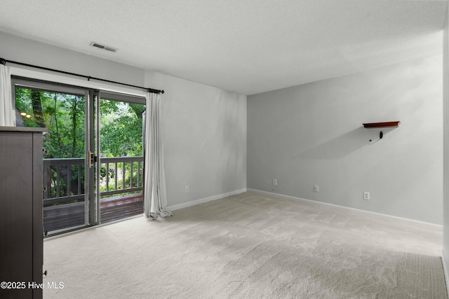 carpeted empty room with baseboards and a textured ceiling