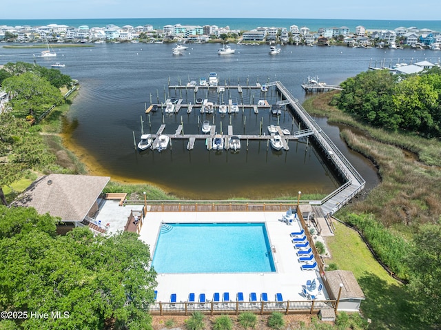 drone / aerial view of a large body of water, a pool area, and a marina
