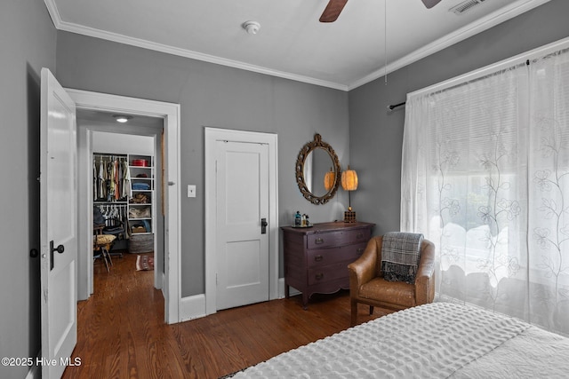 bedroom featuring visible vents, ornamental molding, wood finished floors, baseboards, and a ceiling fan