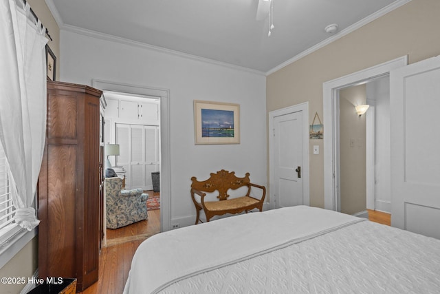 bedroom featuring crown molding, ceiling fan, and wood finished floors